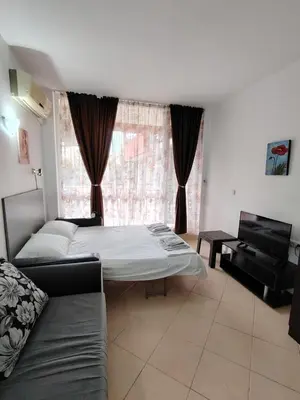 a living room with a bed and a couch at Сънсет Бийч 3 in Sunny Beach