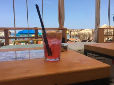 a drink with a straw sitting on a table at Bułgaria na lato apartament z widokiem na morze Sozopol in Sozopol