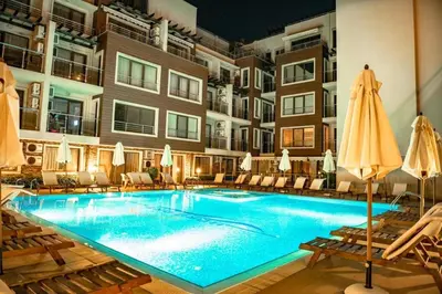 a swimming pool in a hotel with chairs and umbrellas at Horizont Apartment Sozopol in Sozopol