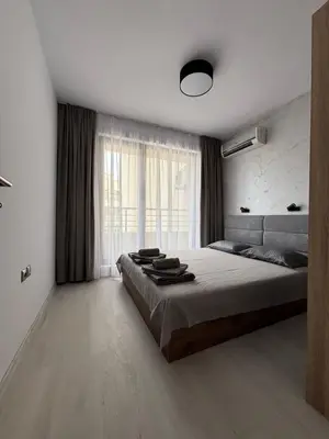 a bedroom with a large bed and a window at Horizont Apartment Sozopol in Sozopol