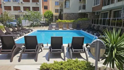 a pool with chaise lounge chairs and a bunch ofitures at Horizont Apartment Sozopol in Sozopol