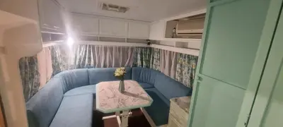 a small living room with a blue couch and a table at Каравана Тиана in Sozopol