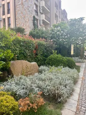 a garden with a sign in the middle of some plants at Wonderful Deluxe Appartement in Cascadas Family Resort Sunny Beach in Sunny Beach
