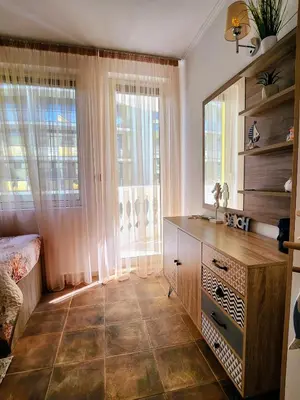 a bedroom with a dresser and a mirror in it at Синьо лято /Blue summer in Sunny Beach