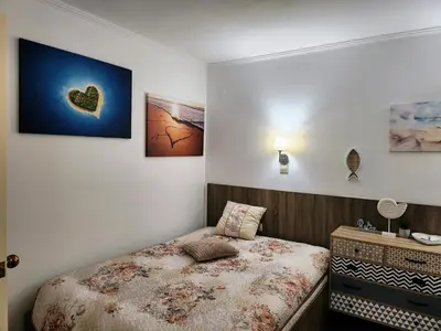 a small bedroom with a bed and a dresser at Синьо лято /Blue summer in Sunny Beach