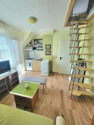 a living room with a spiral staircase in a room at Penthouse Apartments PERLA, Vasiliko in Tsarevo