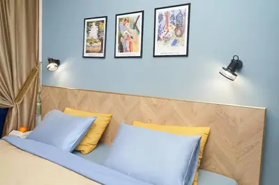 a bedroom with a bed with blue and yellow pillows at Design Studio in Atlantis Resort&SPA, Burgas Airport in Burgas City