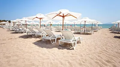 a row of chairs and umbrellas on a beach at Design Studio in Atlantis Resort&SPA, Burgas Airport in Burgas City