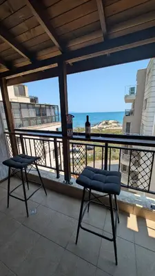 a balcony with two chairs and a view of the ocean at Apartament Piero in Pomorie