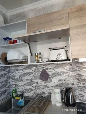 a kitchen with a sink and a tile wall at Apartament Piero in Pomorie