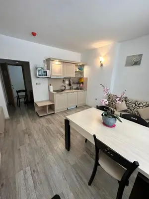 a living room with a table and a kitchen at AVALON, Apartment C102 in Sunny Beach