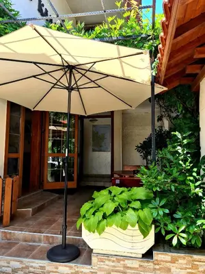 an umbrella in front of a building with plants at Цар Калоян in Primorsko