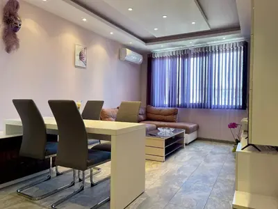 a living room with a table and chairs and a couch at Апартамент Чаролит / Apartment Charoite in Burgas City
