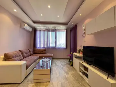 a living room with a couch and a flat screen tv at Апартамент Чаролит / Apartment Charoite in Burgas City