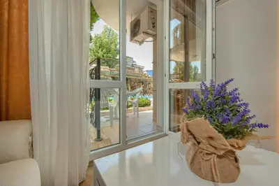 a room with a window and a vase with purple flowers at Sweet Homes 2 Holiday Apartment in Sunny Beach