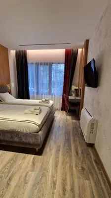 a hotel room with a bed and a television in it at FS Apartments - Family apartment in the top center of Varna in Varna City