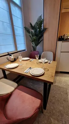 a wooden table with plates and wine glasses on it at FS Apartments - Family apartment in the top center of Varna in Varna City