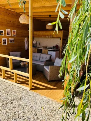 a living room in a wooden house with a couch at CozyHut Бунгало под Наем in Chernomorets