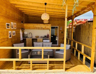a wooden cabin with chairs and a kitchen at CozyHut Бунгало под Наем in Chernomorets