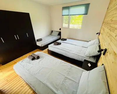 a room with three beds and a window at CozyHut Бунгало под Наем in Chernomorets