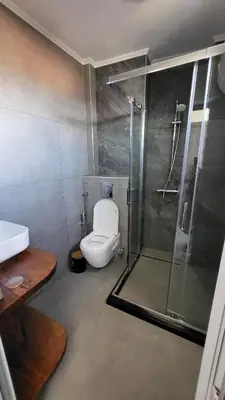 a bathroom with a shower and a toilet and a sink at Q Аpartment in Tsarevo