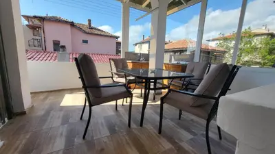 a patio with a table and chairs on a balcony at Q Аpartment in Tsarevo
