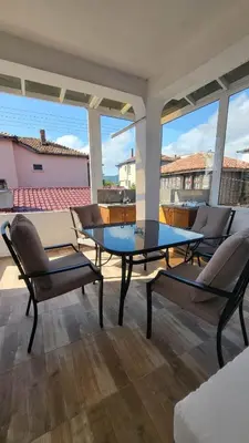 a living room with a table and chairs on a balcony at Q Аpartment in Tsarevo