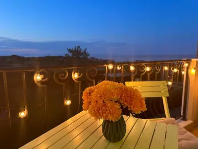a vase of flowers sitting on a table on a balcony at Studio E32 Atia Resort Chernomoretz in Chernomorets