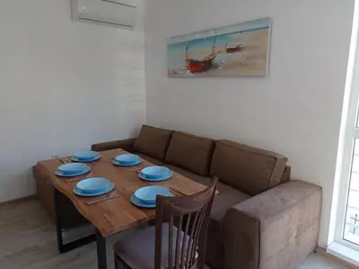 a living room with a wooden table and a couch at Екзарх Йосиф in Tsarevo