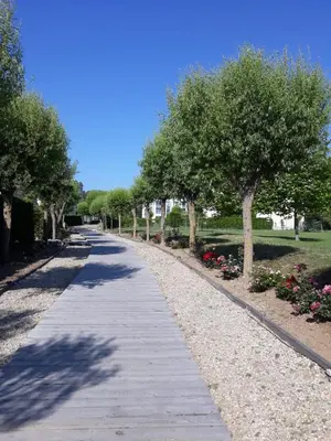 a path with trees and flowers in a park at Апартамент Blue в местност Каваци, Созопол in Sozopol