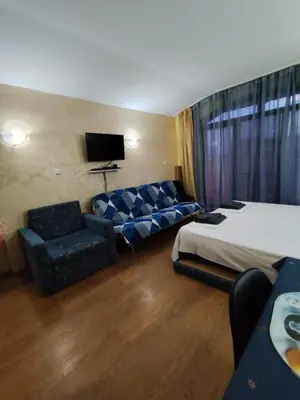 a hotel room with a bed and a couch at Апартхотел Роял Дриймс in Sunny Beach