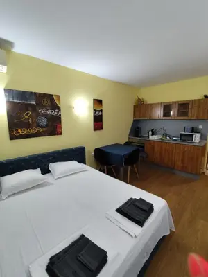 a bedroom with a large bed and a kitchen at Апартхотел Роял Дриймс in Sunny Beach