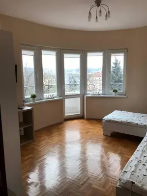 a large room with a hard wood floor and windows at Star Ray Apartment in Varna City