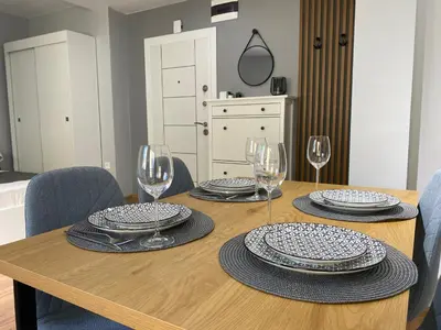 a dining room table with plates and wine glasses at Студио Ирма in Burgas City