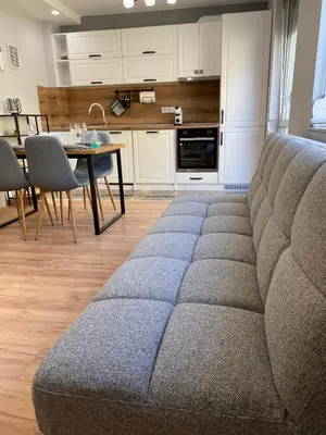 a living room with a couch and a kitchen at Студио Ирма in Burgas City