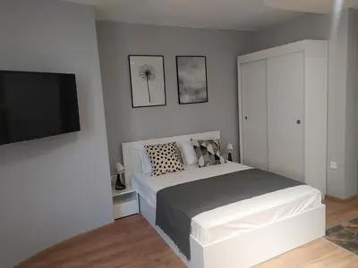 a bedroom with a bed and a flat screen tv at Студио Ирма in Burgas City