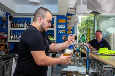 a man standing at a bar making a drink at TSB Roxy Apartments in Sunny Beach