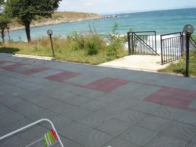 a walkway next to a beach with the ocean at Villa Lazuren Bryag 2 in Chernomorets