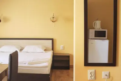 a bedroom with a bed with a mirror and a tv at Horizont Apartments in Sunny Beach