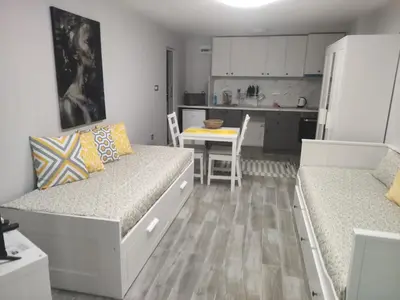 a living room with two beds and a kitchen at Студио за нощувки в центъра на град Бургас. in Burgas City
