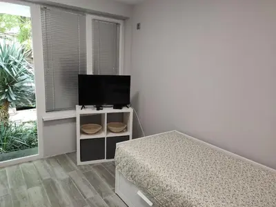 a bedroom with a bed and a flat screen tv at Студио за нощувки в центъра на град Бургас. in Burgas City