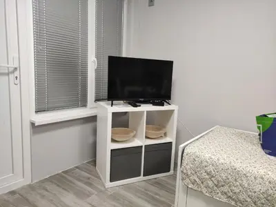 a white cabinet with a tv on it next to a window at Студио за нощувки в центъра на град Бургас. in Burgas City