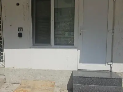 a white door with a window on a building at Студио за нощувки в центъра на град Бургас. in Burgas City