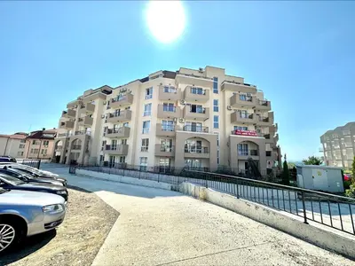 a large building with cars parked in front of it at Ipanema Beach - Menada Apartments in Sveti Vlas
