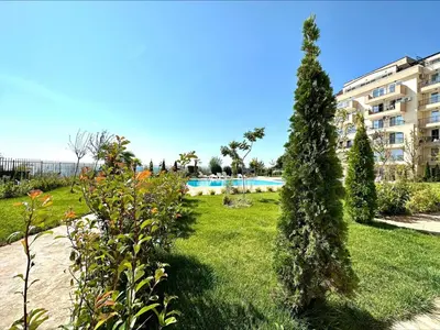 a garden with a swimming pool and a building at Ipanema Beach - Menada Apartments in Sveti Vlas