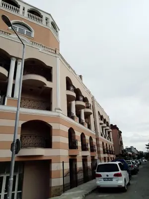 a building with cars parked in front of it at bellissimo студио близо до плажа in Ravda