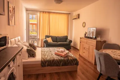 a living room with a couch and a chair at bellissimo студио близо до плажа in Ravda