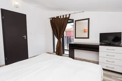 a bedroom with a bed and a desk and a television at Polina Beach in Sozopol