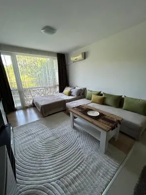 a living room with a couch and a table at Лятно студио in Sveti Vlas