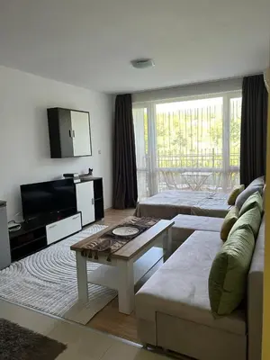 a living room with a couch and a table at Лятно студио in Sveti Vlas